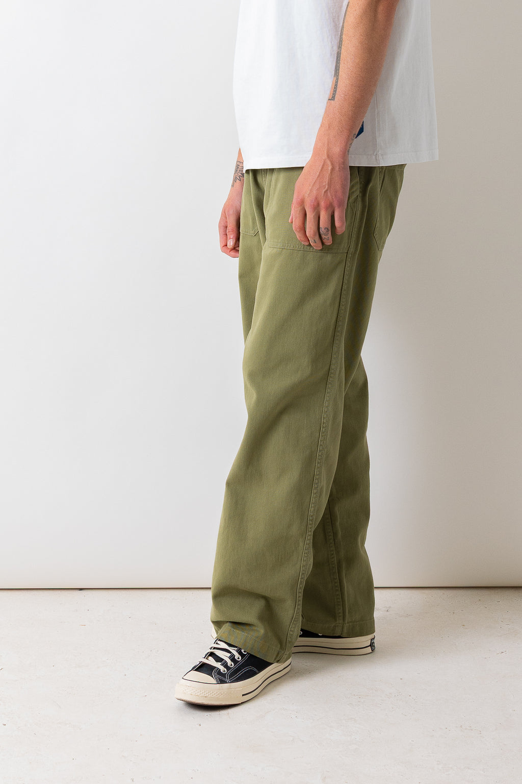 Close side view of a model wearing the Pexwear Tradesman Trouser in Khaki.