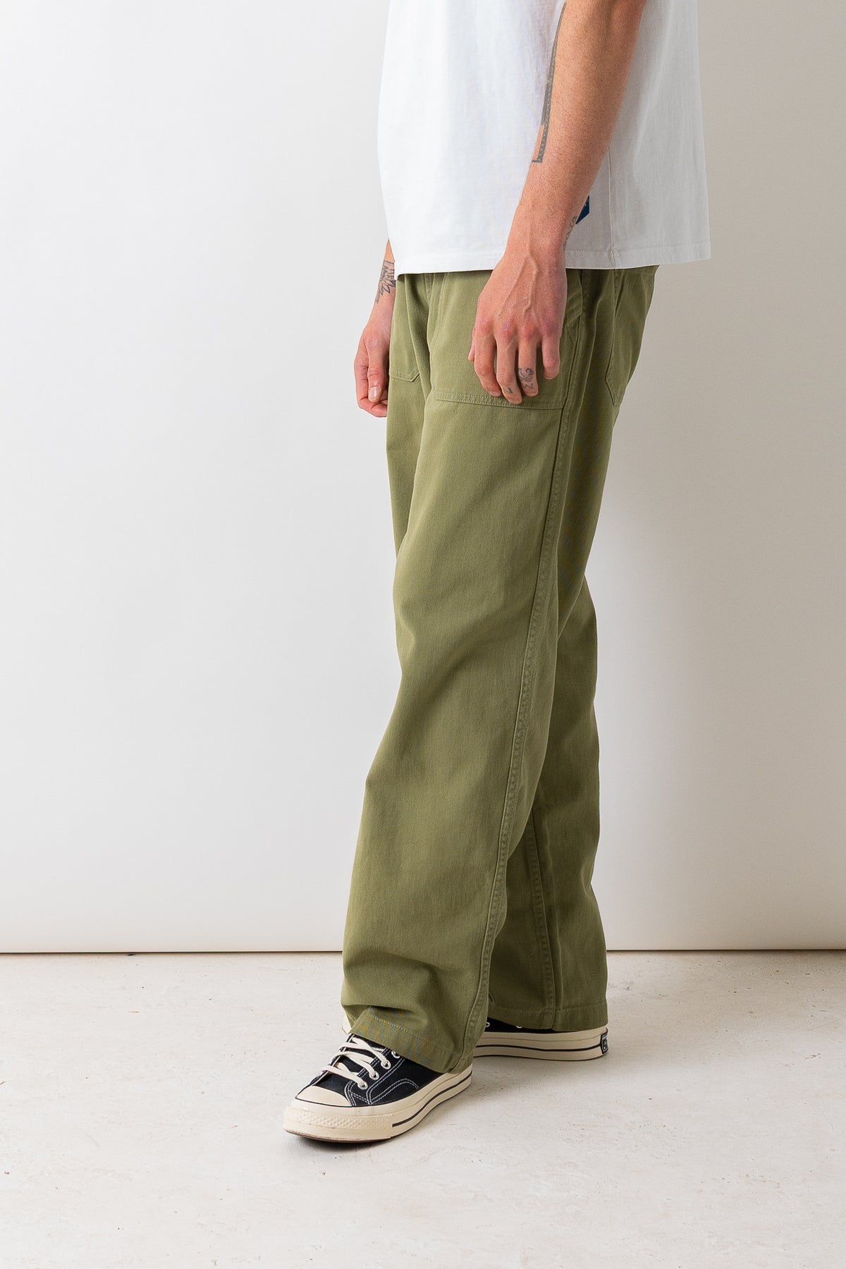 Close side view of a model wearing the Pexwear Tradesman Trouser in Khaki.