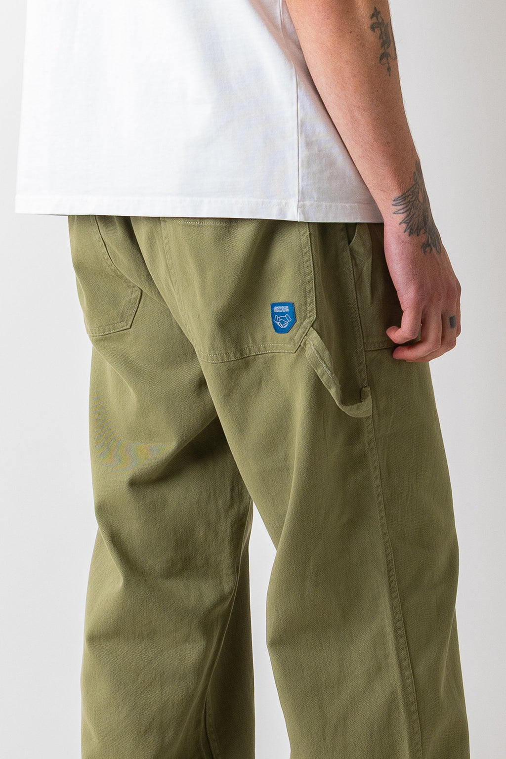 Close rear three-quarter view of a model wearing the Pexwear Tradesman Trouser in Khaki.