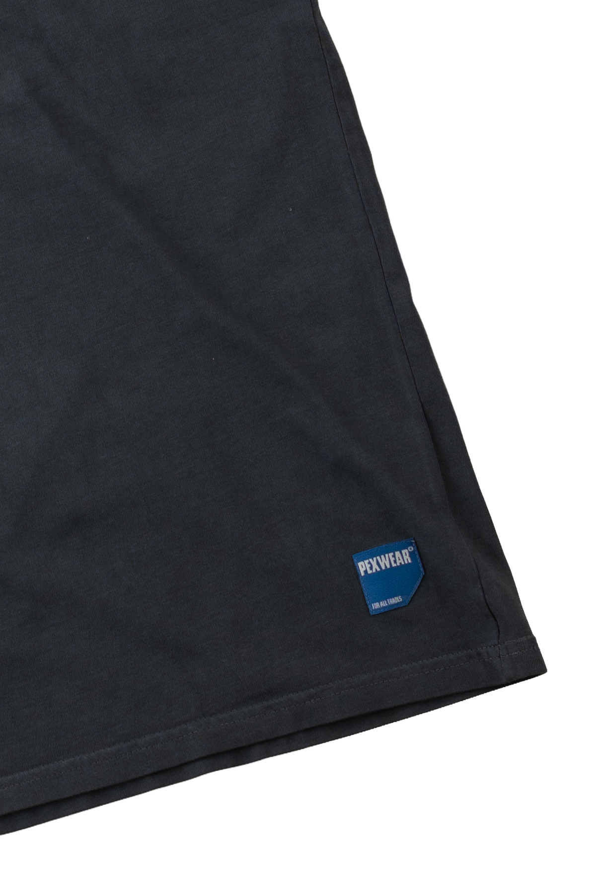 Close-up of a black fabric garment corner with a blue and white PEXWEAR logo patch near the hem, shown on a white background.