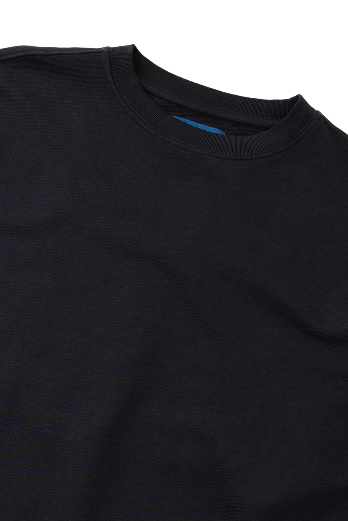 Close-up of a black top with a ruffled mock neck and matching ruffled sleeve detail, photographed against a plain white background.