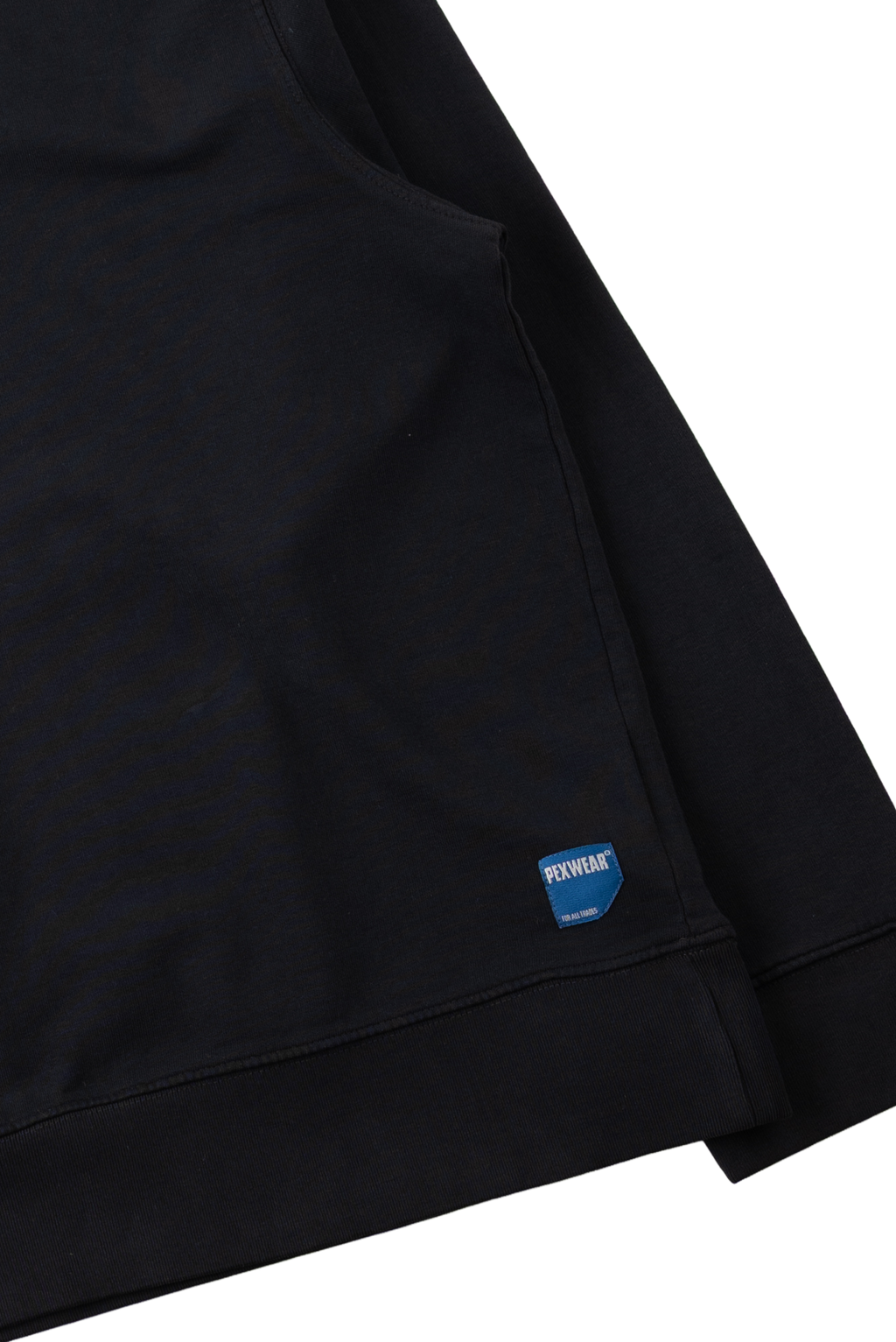 Close-up of a black garment sleeve or cuff with a small blue sewn label reading REVOLVE, shown against a white background.