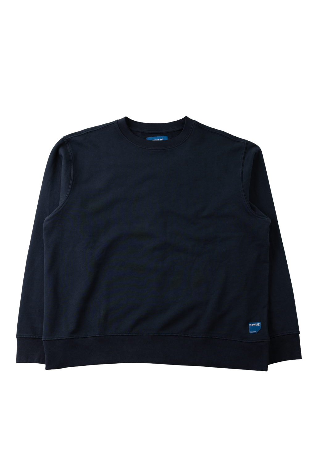 A dark navy blue crewneck sweatshirt with long sleeves, laid flat against a solid white background. A small blue tag is visible on the lower right hem.