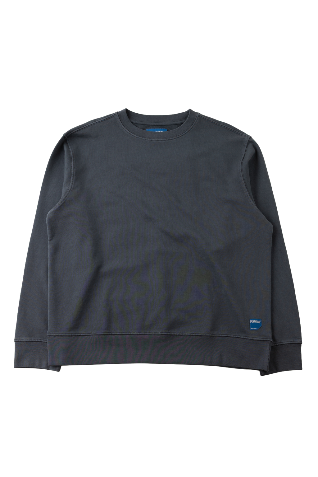 A dark charcoal gray crewneck sweatshirt with ribbed cuffs and hem, laid flat against a solid white background. A small blue tag is visible on the lower right hem.