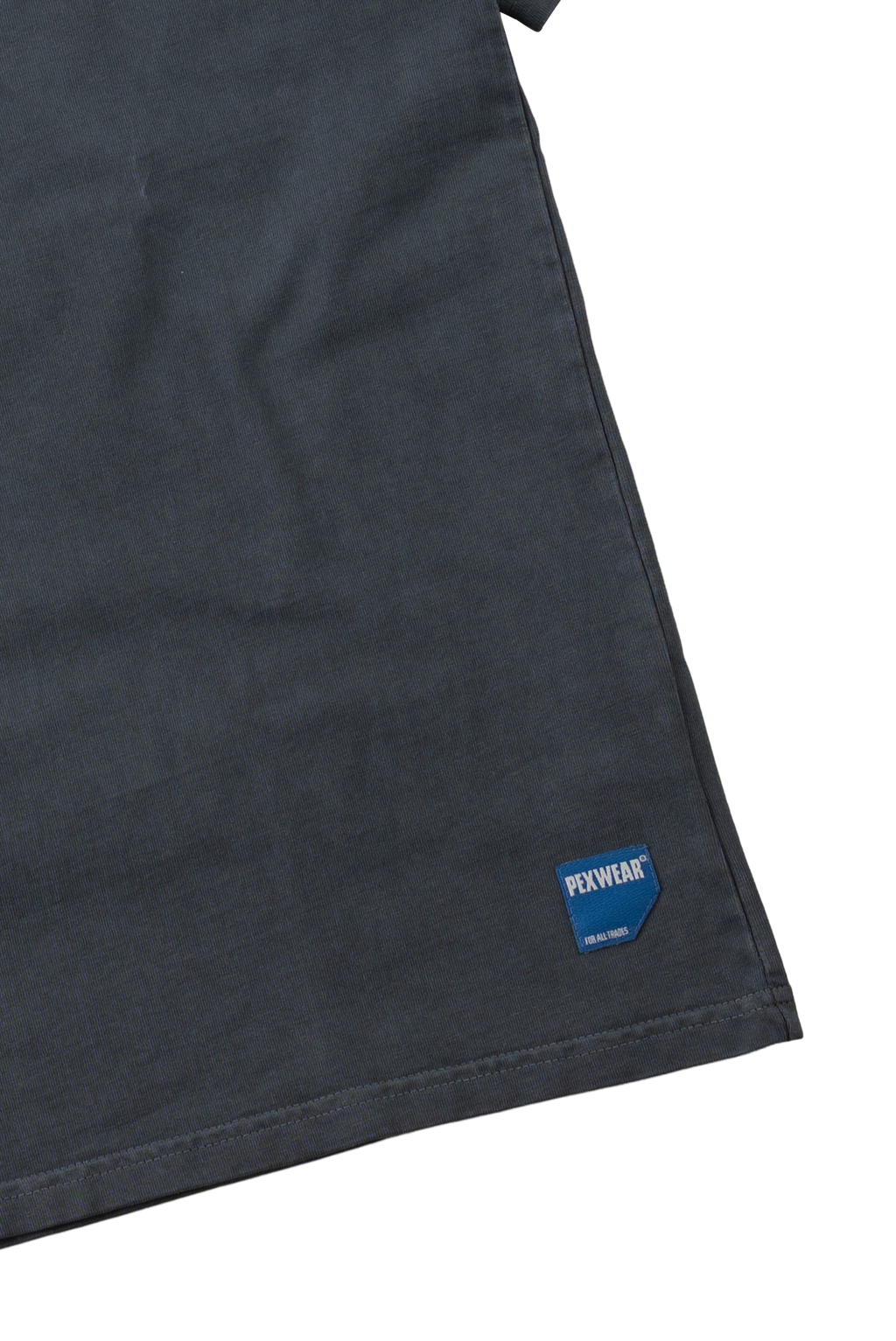 Close-up of a dark charcoal gray fabric garment corner with a small blue and white Foxwear label near the hem, set against a plain white background.